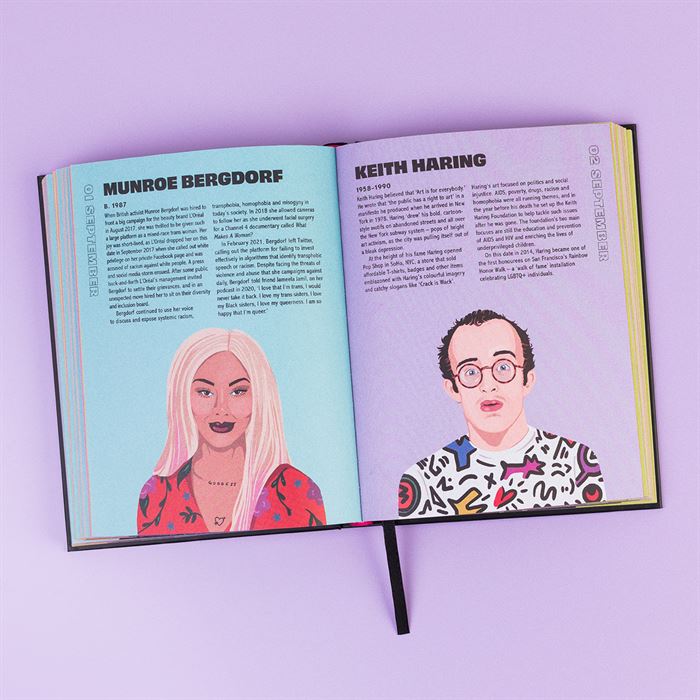 The book 365 Gays of the Year lays open on a purple surface to show the left page on Munroe Bergdorf her image illustrated. On the right is a purple page with Keith Haring as the title and also his image illustrated at the bottom.